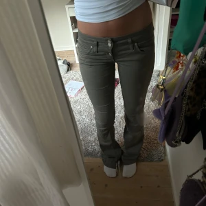 Gröna Lågmidjade jeans  - Såå snygga utsvängda Lågmidjade jeans men så cool färg! Kommer tyvärr inte till användning 💕 innerbenslängden: 88 cm och midjemåttet är 38 cm plus stretch 