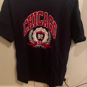 Marinblå t-shirt med tryck  - En jättefin marinblå t-shirt med tryck. Använd MAX 1-2 gånger, men inte kommit till användning mer än det så därför säljer jag. 