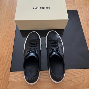 Axel Arigato skor  - Ett par riktigt fräscha arigatos som är i ny skick. Dom är såklart äkta och använda cirka 4 gånger. Ny pris är 2700 men säljer dom för 1000, storleken är 46,5