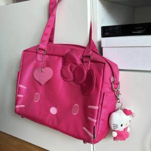 Otroligt cool väska med plats för laptop samt många fack både på insidan och utsidan. Hello Kitty gosedjur hängandes på sidan som är avtagbar. Storlek ca 37x27 cm