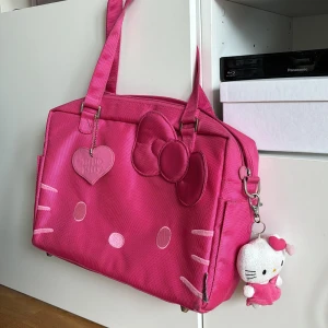 Väska laptop Hello Kitty - Otroligt cool väska med plats för laptop samt många fack både på insidan och utsidan. Hello Kitty gosedjur hängandes på sidan som är avtagbar. Storlek ca 37x27 cm