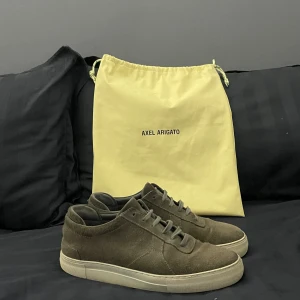 Axel arigatos - Säljer nu mina gammla skor från Axel arigato. Dom är väl använda men har fortfarande mycket liv i sig. Dom är gjorda av grå mocka. Har tyvärr inte lådan men har kvar påsen som ingick till skorna när jag köpte dom. Det är bara att höra av sig vid fråg