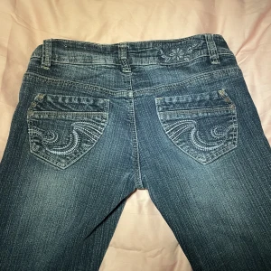Jättecoola lågmidjade jeans - Mörkblå jeans i ett perfekt skick med jättecoola detaljer 💕 sitter lågmidjade och bootcut! Säljer för att de tyvärr är för korta på mig🥹