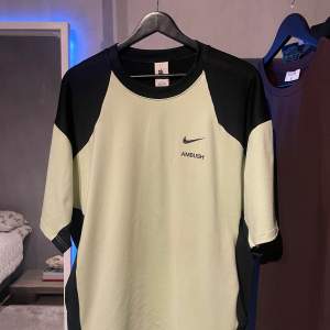 Hej! Säljer denna limited edition t-shirten från Nikes samarbete med det japanska märket Ambush. Tshirten är i toppenskick och har en neongrön färg (syns dåligt på bilderna). Den är köpt på ”naked copenhagen” för runt 1200 kr förra året! Oversized fit!
