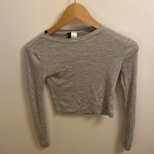 Grå tröja från divided - Säljer denna supersköna ljusgråa tröjan från hm/divided. Säljer för att den är för liten för mig och ska inte vara en crop top utan lite av magen kanske syns beroende på hur lång du är osv.💗   Pris kan diskuteras 