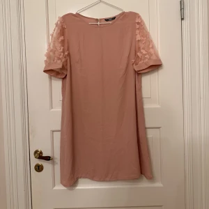 Klänning i gammelrosa  - Rosa klänning med genomskinliga puffärmar med blommor på. Ljusare i verkligheten, ljus gammelrosa. Chiffong-material. Från Shein, i storlek XL men passar mer om en L. Aldrig använd, endast provad. 