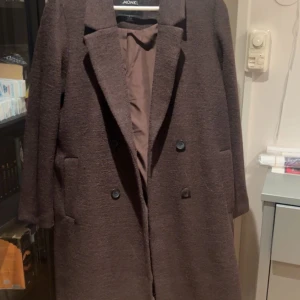 Brun kappa från monki - Brun kappa perfekt för vinter/höst Aldrig använd Storlek 36 Nypris 800kr  Produktnummer: 0631964044