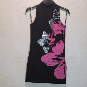 Klänning - Figursydd klänning med rosa/silver blomtryck. Fint skick