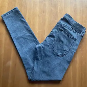 Snygga gråa jeans från märket Lee. Jeansen är använda men i bra skick, utöver en liten blekningsfläck vid vänster ficka. Vårat pris: 199kr. Storlek: W32 L31