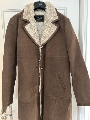 Mocka/skinn kappa - Kappan är i princip oanvänd. Äkta skinn, typ borstad mocka. Stl 44 men känns mer som 42.  Varm och tjock. 