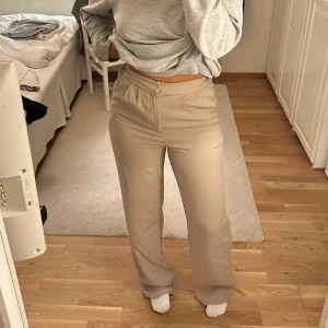 ”Kostymbyxor” - Ett par ”mjukare kostymbyxor” från bikbok, påminner lite om ett par linnebyxor men är ej i linne. Har resår där bak i midjan. Mycket fint skick! Är 172 cm lång och de går hela vägen ner till fötterna på mig!