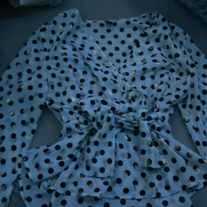 Blus - En jätte söt och fin blus som är i vit med svarta och gulda prickar på den med fina knytband runt midjan. Den har även väldigt utsvängda ärmar. Den är nästan helt oanvänd utan täcken av användning och är i ett perfekt och nytt skick. 