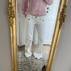 Lågmidjade jeans - Sjukt snygga lågmidjade vita bootcutjeans med coola detaljer💗Jättefint skick! Passar M/L. Skriv vid funderingar och kolla in mina andra annonser✨