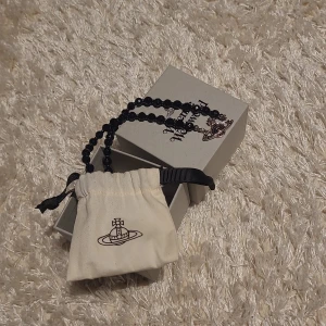 Vivienne Westwood svart choker med silver detaljer  - Helt nytt, aldrig använt. Bara legat i sin originalförpackning. Sitter ganska högt upp på halsen, mycket fin accessoar. 