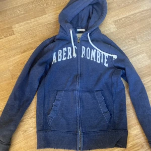 Abercrombie hoodie - Snygg mörkblå abercrombie hoodie, lite sliten mend et gör den bara ännu snyggare