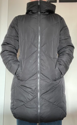 Lång svart dunjacka  - Lång svart dunjacka för dam, väldigt fint skick. 