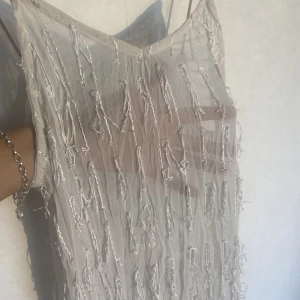 Unik klänning med fransar  - Söt unik långklänning med fransar som är något genomskinlig.   Passar S