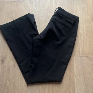 Lågmidjade kostymbyxor  - Ett par lågmidjade kostymbyxor från bikbok i storlek 34. Jag säljer dom för 250kr men säg gärna till om ni har ett annat pris förslag.