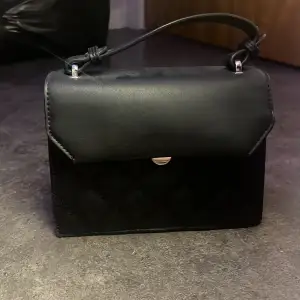 Jättefin svart handväska med ganska mycke utrymme. Har tyvärr inget axelband till den