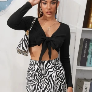 Svart tröja - En jättecool svart tröja som man knyter i mitten. Då den knyts i mitten kan man även styla den på olika sätt. I storlek S. Lånade bilder.  Skriv för mer info och bilder.