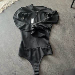 NY Body XS - Festligare Body med volanger vid bysten Svart Nelly one Storlek: XS/34  Aldrig använd, prislapp kvar!! 