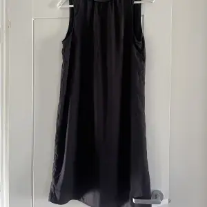 Supersöt klänning i svart med rosett bak. 