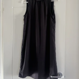 Svart klänning  - Supersöt klänning i svart med rosett bak. 