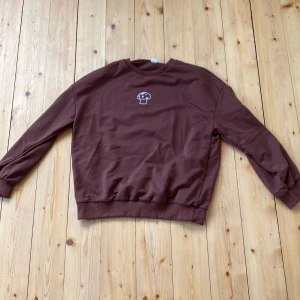 Brun crewneck med design - Den här bruna crewneck från Shein är perfekt för höst då den är tunn. Den har en fläck som är extremt svår att se men den är inte knopptig. Säljer då den inte passar 💕