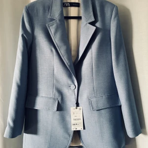 Kavaj från Zara - Superfin ljusblå kavaj från Zara. Inköpt till en bröllopsfest, men vädret ville annorlunda, så helt oanvänd. Lite oversized och rak modell med en knapp. Passar både till vardag och fest. Inköpt för 699 kr. Säljer för 400 kr så riktigt bra pris. 