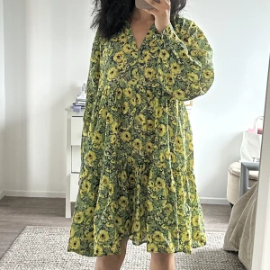 En supersöt klänning💚 - Säljer en superfin klänning med blommigt mönster som skiftar i grönt & gult🌼 Använd fåtal gånger✨lite genomskinlig i vissa ljus