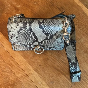 Rebecca Minkoff  skinnväska - Väska med axelrem och silver detaljer.  Mått 23 cm  bredd 9cm djup & 15 cm hög.  Tre fack inne i väskan och ett på utsidan. 