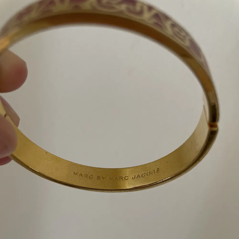 Fint guldigt och rött stelt armband från Marc by Marc Jacobs. Kan öppnas.. Accessoarer.