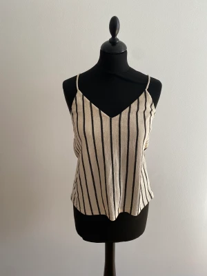 Randig topp  - Randig topp med tunna axelband och tyg med textur i Strl S. Använd sparsamt 