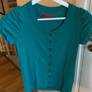 Tröja - Grön tröja med knappar. Köpt i Antibes, Frankrike i 2014. Knappt använd, inga skador. Finns ingen storlek men skulle gissa på S-M❤️