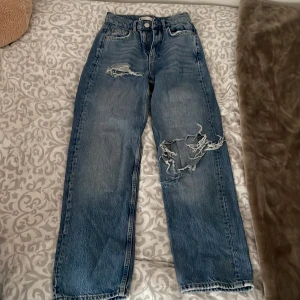Blåa jeans med hål - Ett par blåa jeans från Ginatricot, jättefina! Men tyvärr för små. 