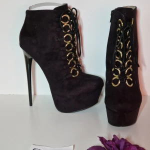 Boots i mockaimitation strl 38 - Highheel stilettklackar i mockaimitation med gulddetaljer  Klackhöjd ca 16 cm platå ca 5 cm  Helt nya och oanvända!