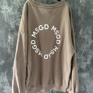Sweatshirt  - Beige sweatshirt från missguided med tryck på ryggen. Finns sömmar där bak vid lappen som syns på utsidan, det syns på bilden och var så när jag köpte den. Även en liten fläck på magen. Annars i bra skick. Inköpspris ca 400