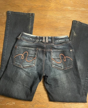 Lågmidjade jeans - Midja: 80 cm innerbenslängd: 84 cm Lågmidjade jeans från vero moda med mönster på bakfickorna. Köpta här på plick för ca 400kr men kommer ej till användning längre. Slitna längst ner på benen men inga andra anmärkningar💞 