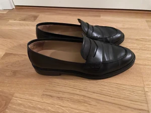Svarta loafers - Svarta loafers från Flattered modell Sara, storlek 39. Sparsamt använda så i mycket bra skick.