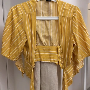 Somrig blus från Gina Tricot - Blus från Gina Tricot som både har knappar och ett band man knyter. Storlek 34 💕