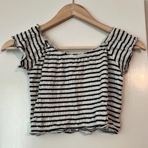 Crop top - Randig crop top som kan dras ner på armar så det blir öppna axlar.  Lite tight på mig som har bredare axlar.  Använd fåtal gånger.