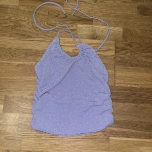 Glittrig topp  - En jättesnygg lila glittertopp helt oanvänd. Jag säljer den för den inte kom till någon användning 