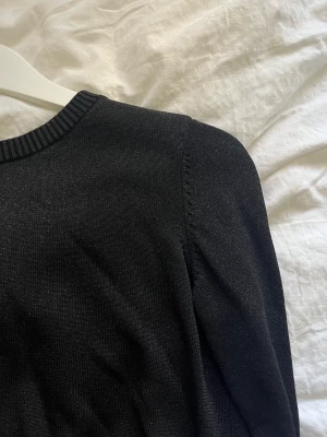 Svart glittrig tröja  - Svart glittrig tröja från Stockh lm i strl XS  Dragkedja på ryggen 