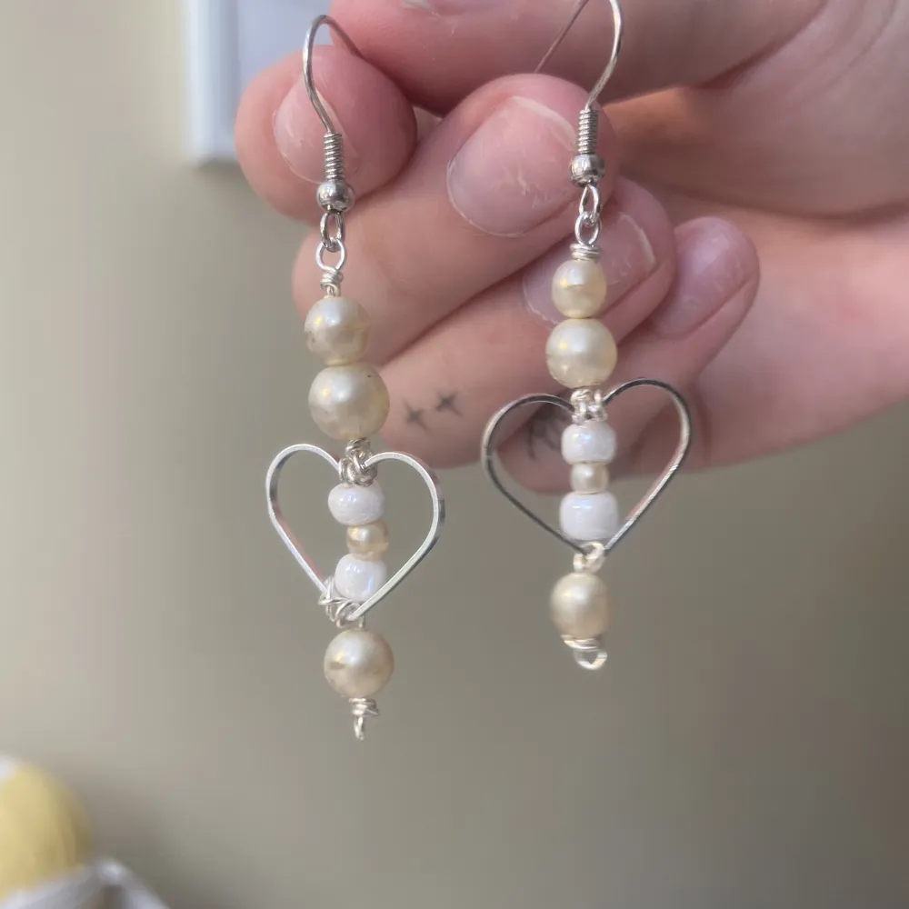 Egengjorda örhängen! vita och benvita pärlor med hjärta i rostfritt stål. (Okända pärlor). Accessoarer.