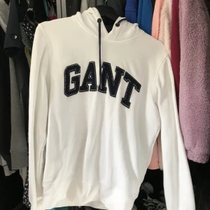Vit GANT hoodie  - En vit hoodie med mörkblå insida av luvan och text. Används ej så vill ha sålt den. Vid frågor eller funderingar, skriv gärna ! ✨✨ Skickar gärna fler bilder om det behövs! 