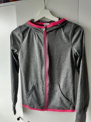 Grå träningströja  - Tunn grå träningströja med rosa "sömmar".  Från H&M i storlek 146/152 även som en Xs. 