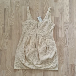 Spetsklänning - Fin spetsklänning med dragkedja framtill. Oanvänd, prislappen sitter kvar.