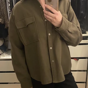 Vår/höstjacka - Vår/höstjacka från Gina Tricot i storlek XL. Valde XL för att ha en mer oversized look men använde jackan 2 gånger bara. Färg mörkgrön/kaki.  Plagget finns i Ursvik, Sundbyberg om du önskar hämta det.