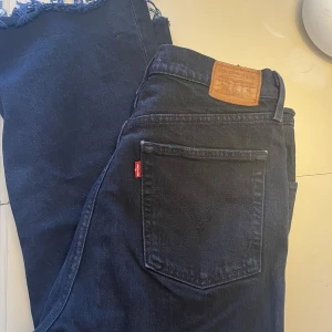 Svarta levisjeans  - Svarta Levisjeans, höga i midjan och raka i benen. 