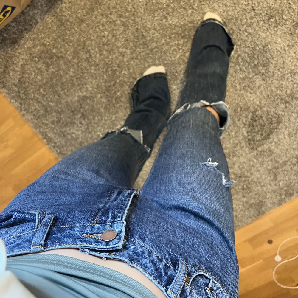 Bootcut jeans med slitningar. Alldeles för långa för mig och har inte orkat göra nått åt det, så väldigt sparsamt använda. De få gånger de använts har jag dock trampat lite på de. Syns knappt men bild kan självklart fås på det. Sista bilden visar färgen. Jeans & Byxor.